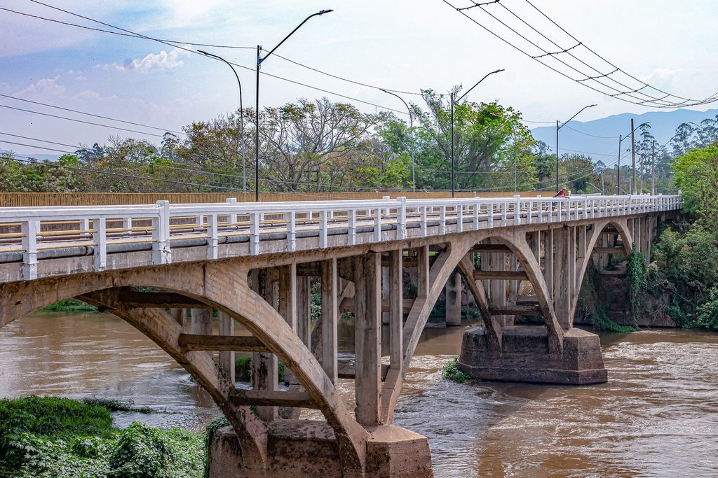 Ponte antiga de concreto em arcos sobre o Rio Paraíba do Sul, em Tremembé, com o rio barrento correndo embaixo