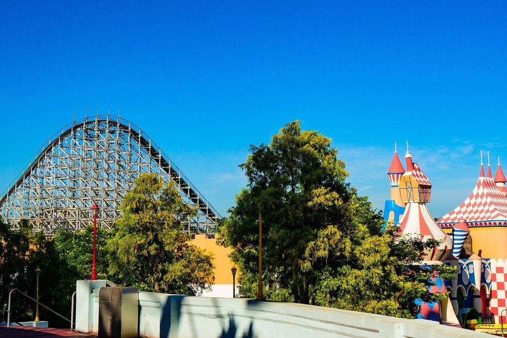 Montanha-russa de madeira e torres coloridas de castelo no parque Hopi Hari sob céu azul